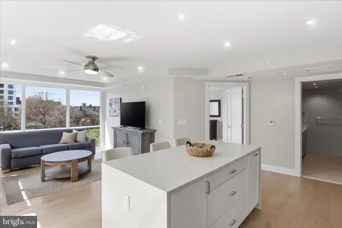 a living room with furniture a flat screen tv and a large window