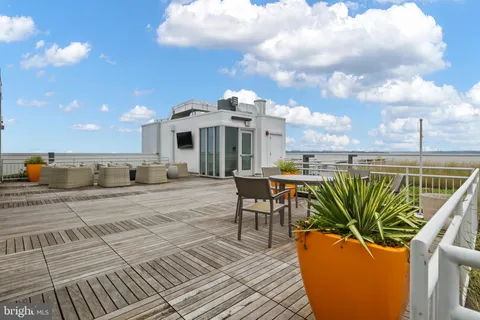 a roof deck with outdoor seating and city view