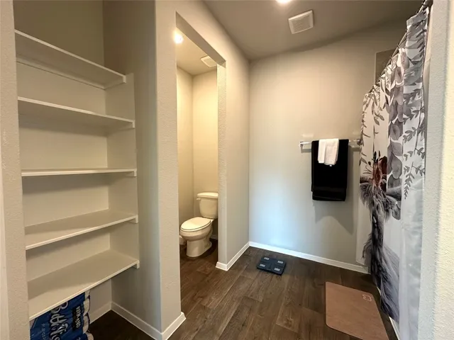 a view of walk in closet with clothes