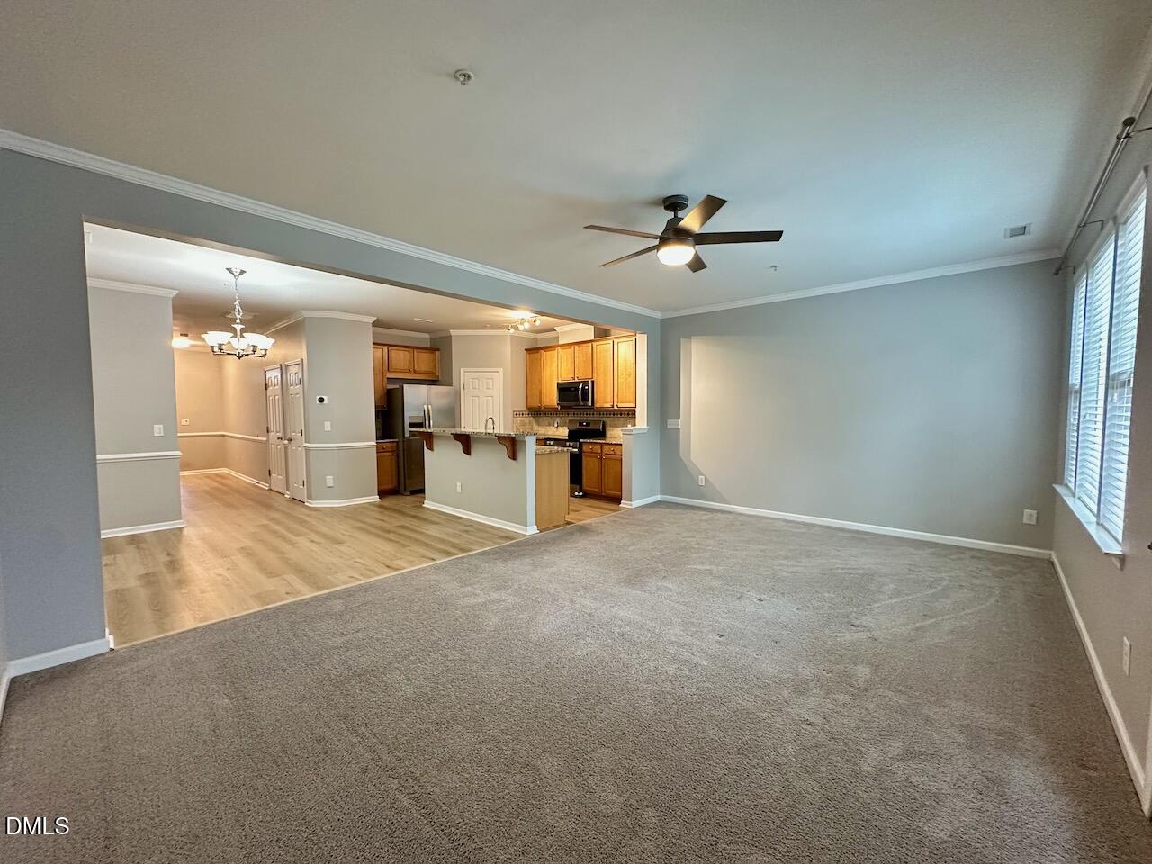 2705 Casper Creek Lane Raleigh, NC 27616 - Photo 12 of 35 an empty room with chandelier fan and windows