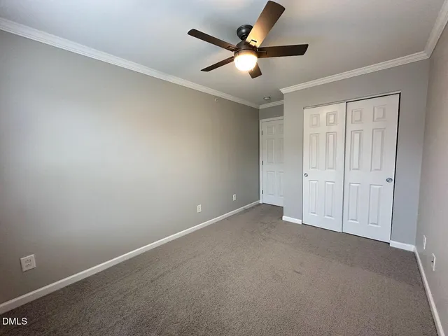 an empty room with a ceiling fan and a window