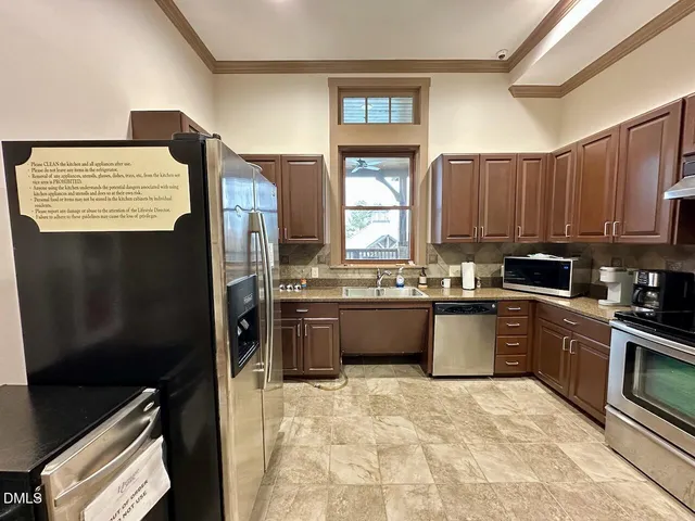 a kitchen with stainless steel appliances granite countertop a refrigerator sink and stove