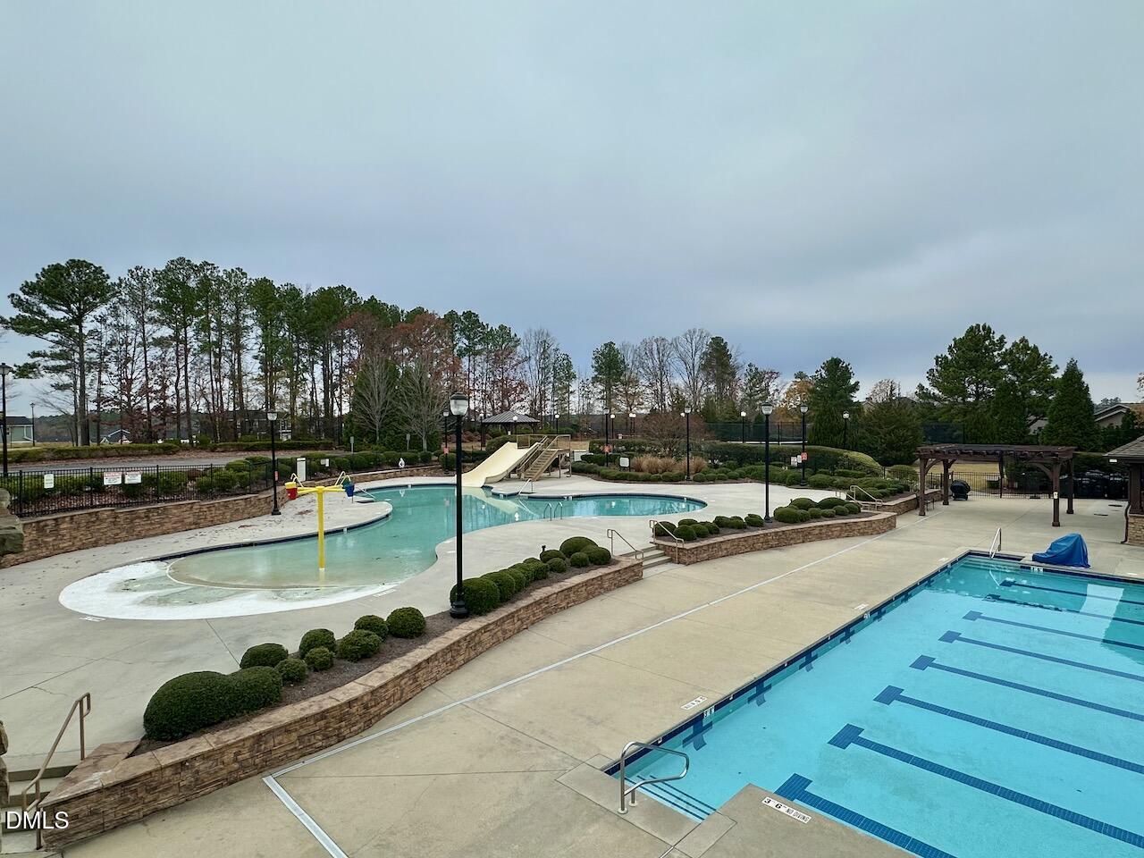 2705 Casper Creek Lane Raleigh, NC 27616 - Photo 32 of 35 a view of a swimming pool with outdoor seating and trees in the background