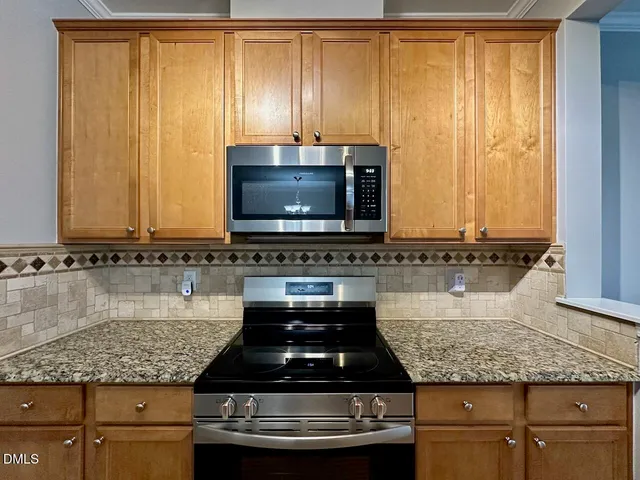 a kitchen with granite countertop a sink and a stove top oven