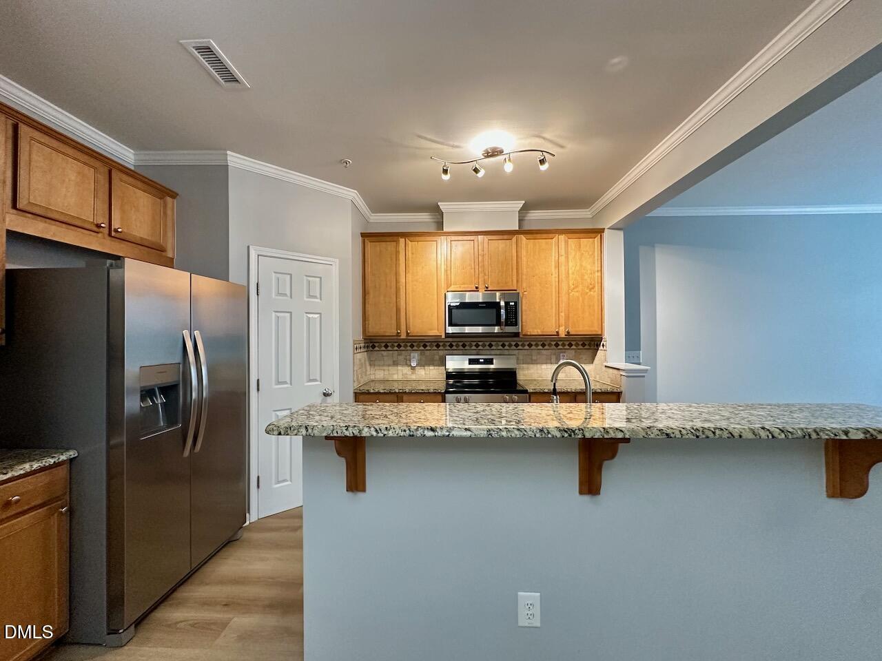 2705 Casper Creek Lane Raleigh, NC 27616 - Photo 10 of 35 a kitchen with stainless steel appliances granite countertop a sink refrigerator and cabinets