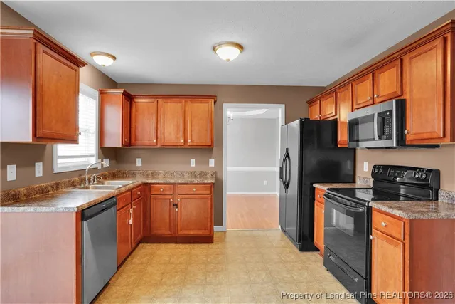 a kitchen with stainless steel appliances granite countertop a stove a sink dishwasher a refrigerator and a microwave oven