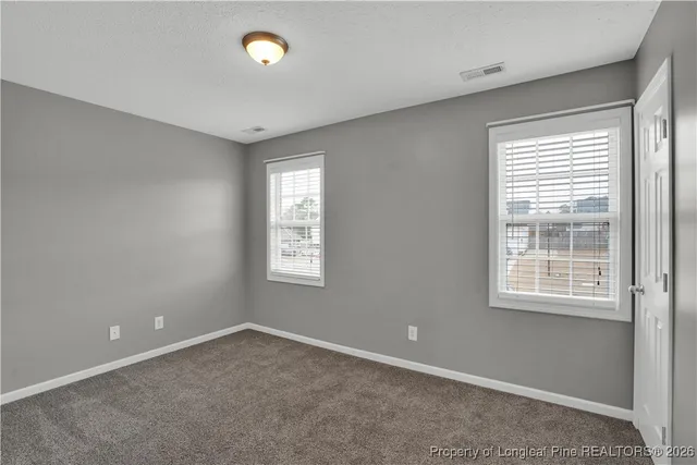 a view of an empty room with a window and a bathroom