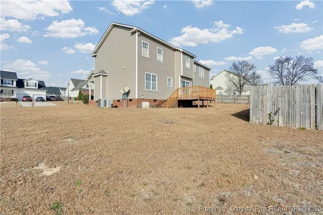 a view of house with backyard and wooden fence