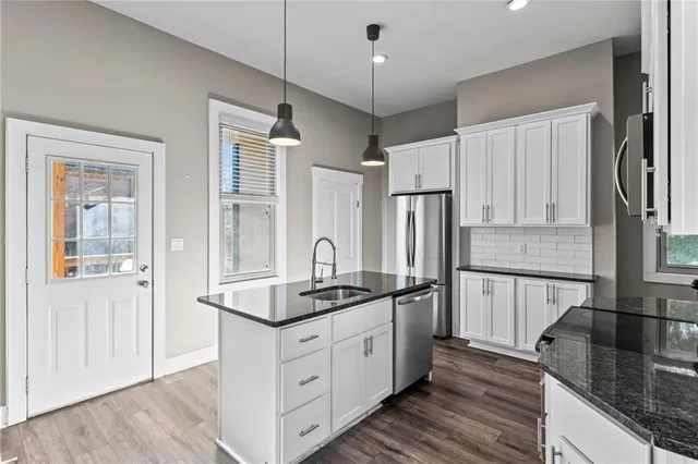 a kitchen with stainless steel appliances granite countertop a sink stove and refrigerator