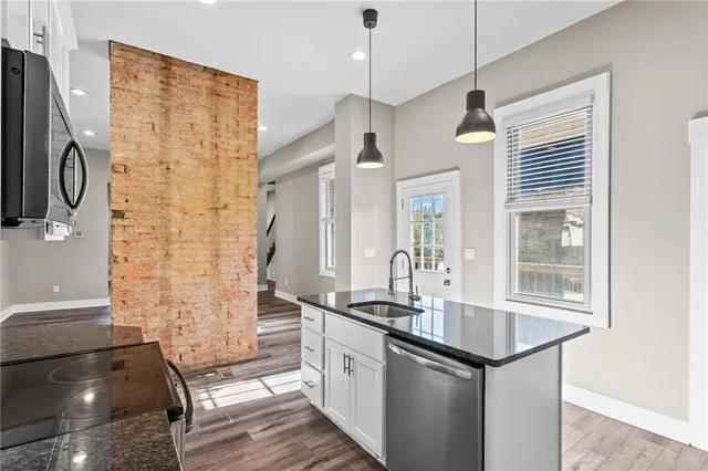 a kitchen with stainless steel appliances a sink and a refrigerator