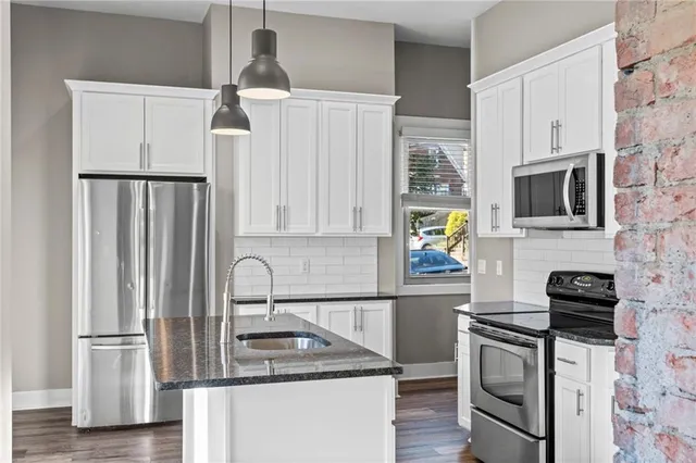a kitchen with stainless steel appliances granite countertop a refrigerator sink and stove