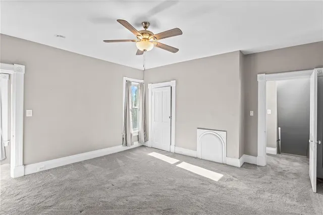 an empty room with closet and a chandelier fan