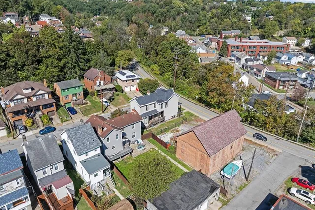 an aerial view of a house with a garden and lake view