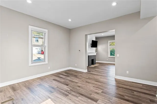 an empty room with wooden floor and windows