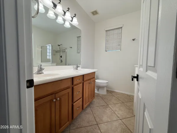 a spacious bathroom with a double vanity sink mirror and toilet