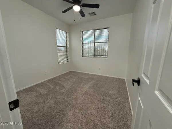 an empty room with windows and fan