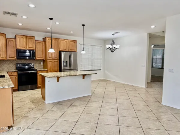 a large kitchen with a large counter top stainless steel appliances and cabinets