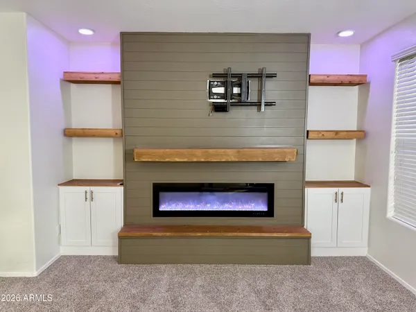a living room with stainless steel appliances furniture a rug and a window