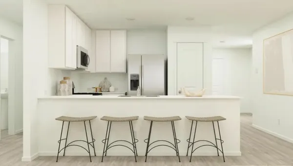a kitchen with stainless steel appliances granite countertop a table chairs in it and white cabinets