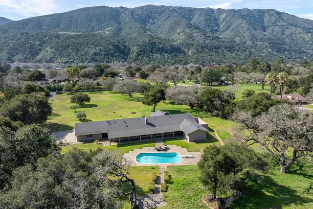 an aerial view of a house with a swimming pool outdoor seating and yard
