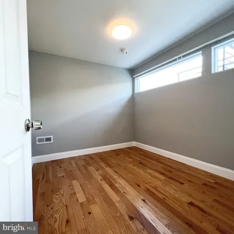 a view of empty room with wooden floor