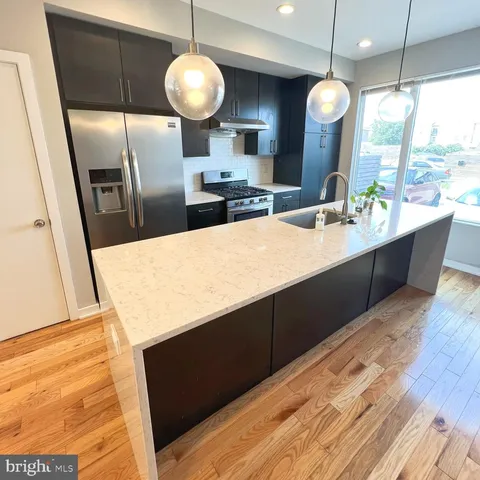 a kitchen with stainless steel appliances wooden cabinets a sink and a large window