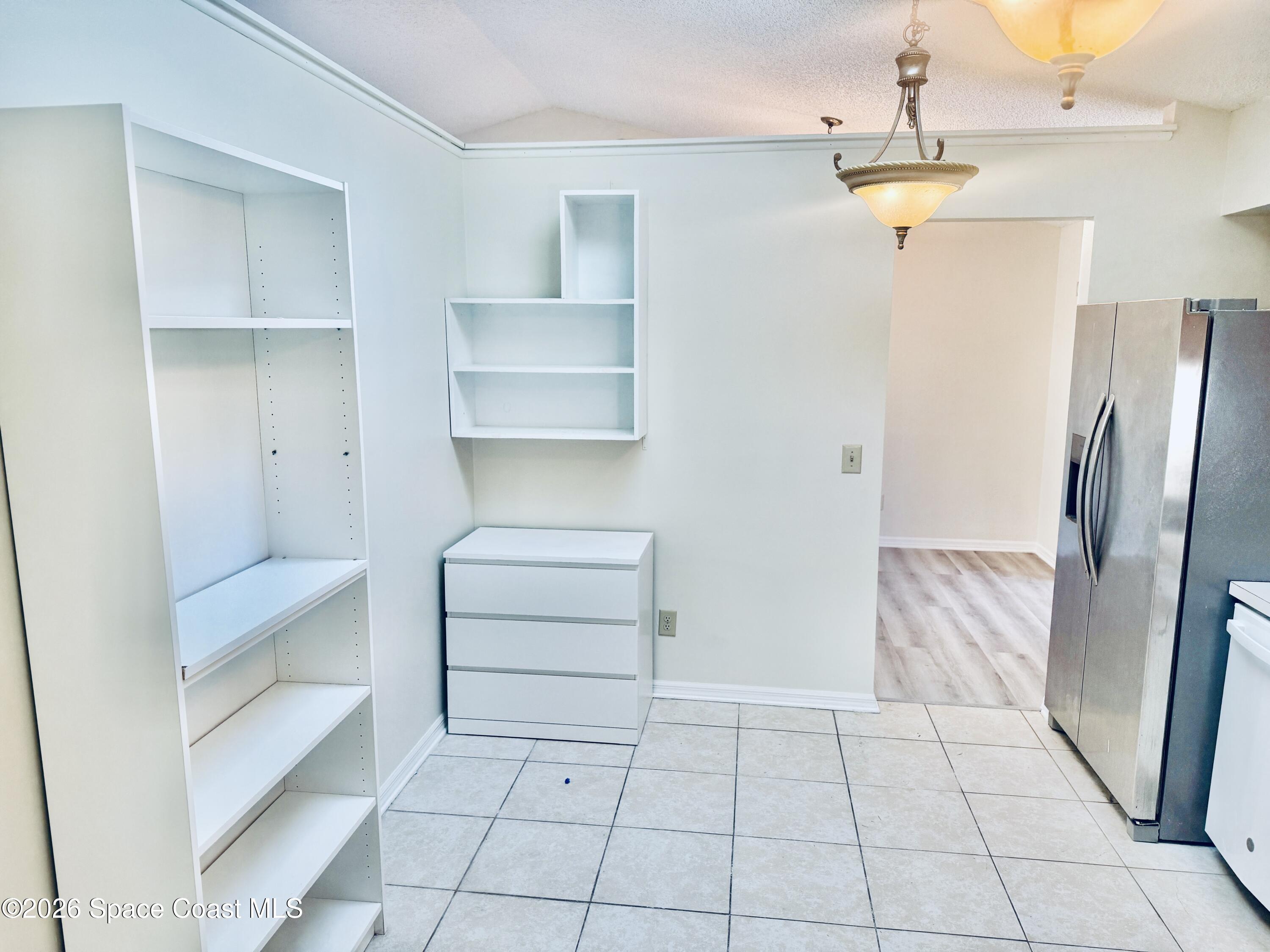 4795 Riverside Road Palm Shores, FL 32935 - Photo 12 of 33 a view of a refrigerator in kitchen and an empty room
