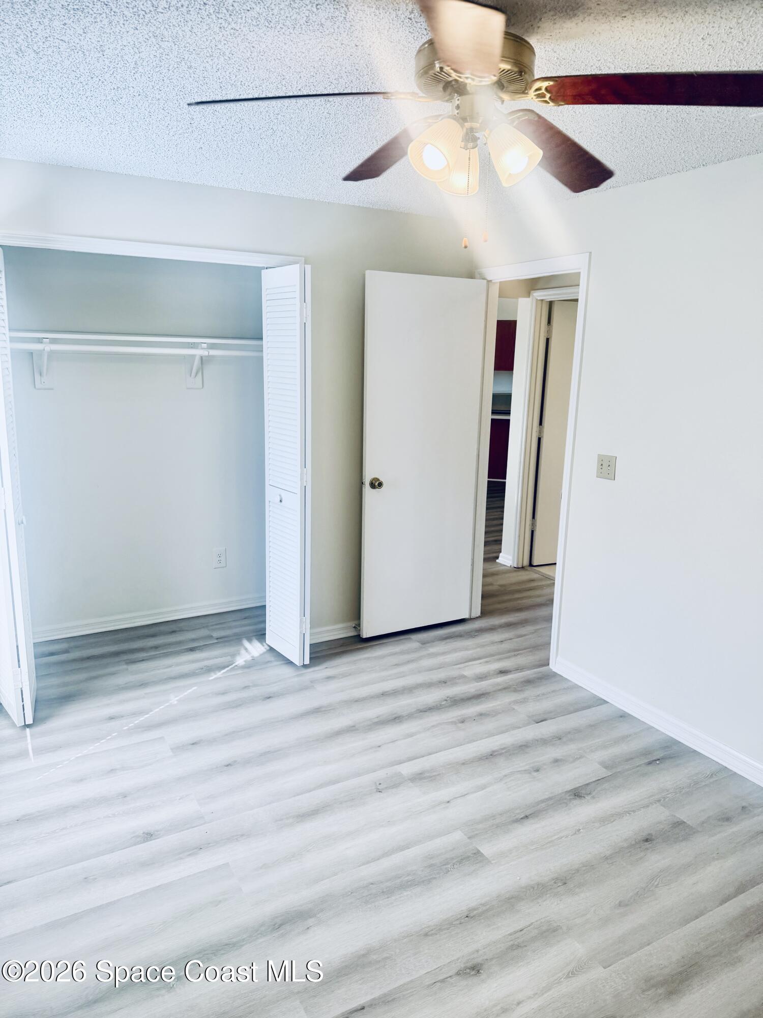 4795 Riverside Road Palm Shores, FL 32935 - Photo 22 of 33 a view of an empty room with wooden floor and a ceiling fan