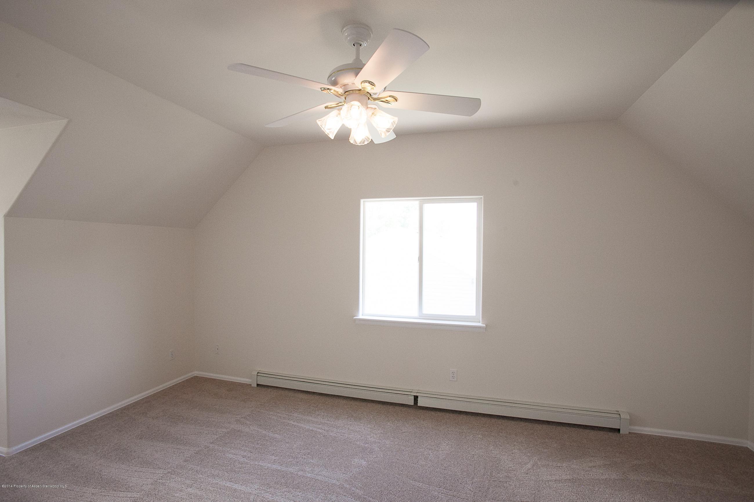 413 Evergreen Drive Rifle, CO 81650 - Photo 15 of 19 an empty room with windows and chandelier fan