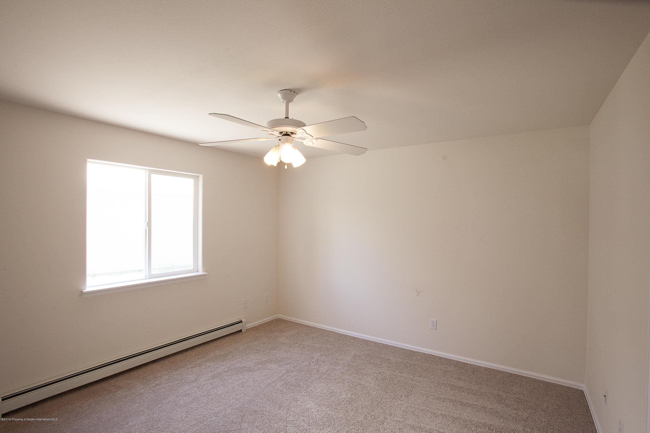 413 Evergreen Drive Rifle, CO 81650 - Photo 5 of 19 an empty room with windows and fan