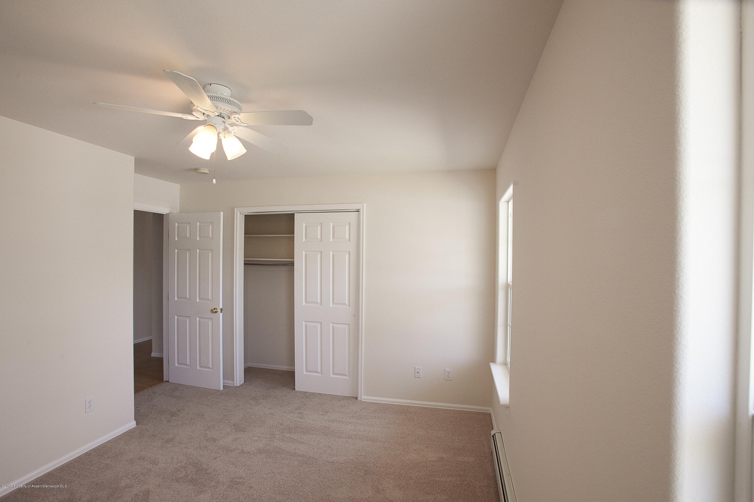 413 Evergreen Drive Rifle, CO 81650 - Photo 10 of 19 an empty room with a ceiling fan and a bathroom