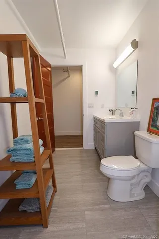 a bathroom with a toilet sink and mirror