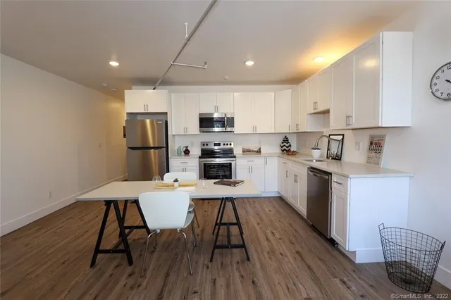 a kitchen with a table chairs refrigerator and microwave