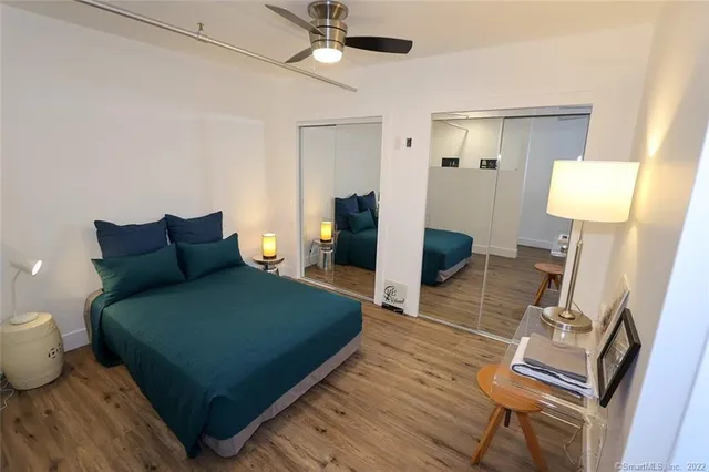 a bedroom with a bed and wooden floor