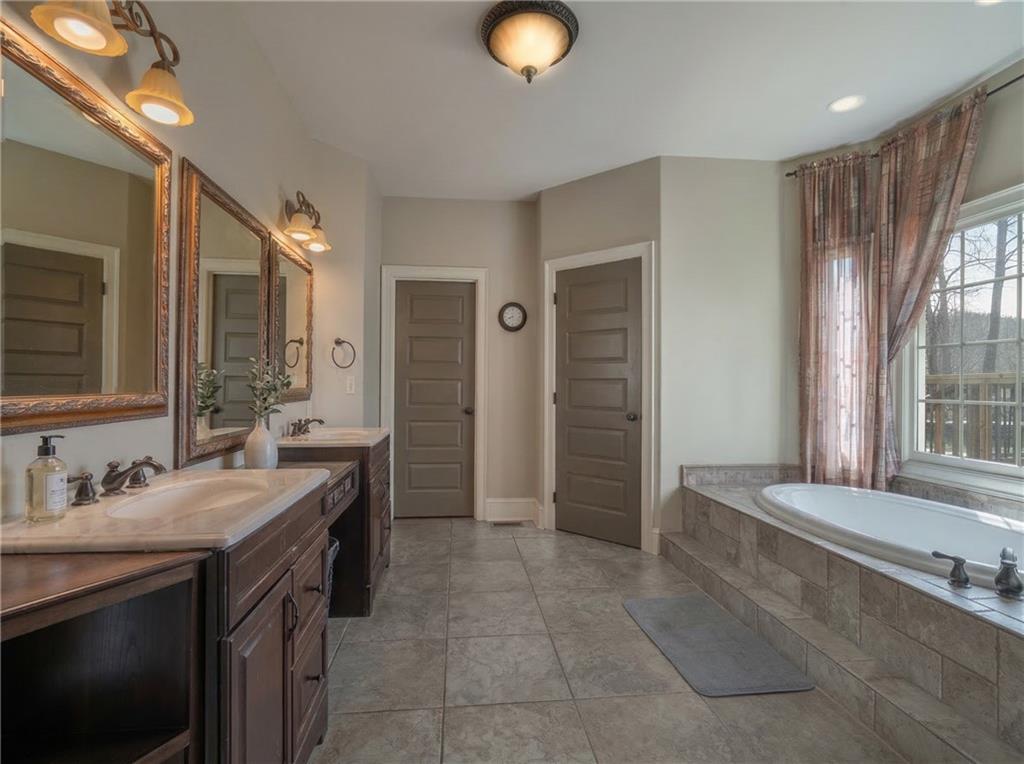 723 Sulphur Springs Road Southeast Fairmount, GA 30139 - Photo 21 of 54 a spacious bathroom with a granite countertop sink and a mirror