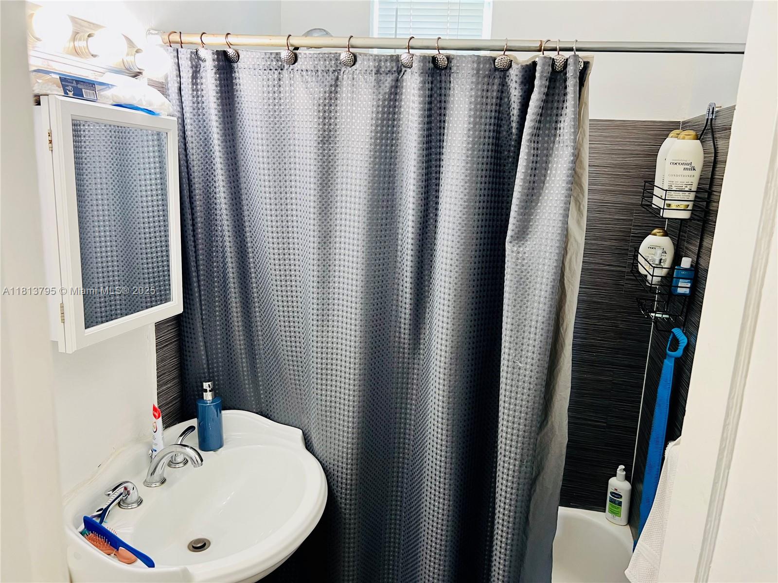 320 80th Street, Unit 6 Miami Beach, FL 33141 - Photo 21 of 33 a bathroom with a sink and mirror