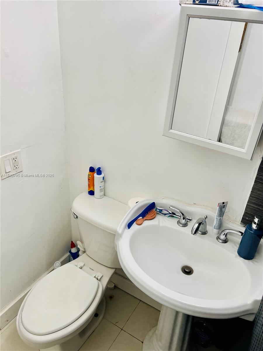 320 80th Street, Unit 6 Miami Beach, FL 33141 - Photo 22 of 33 a bathroom with a sink a toilet and mirror