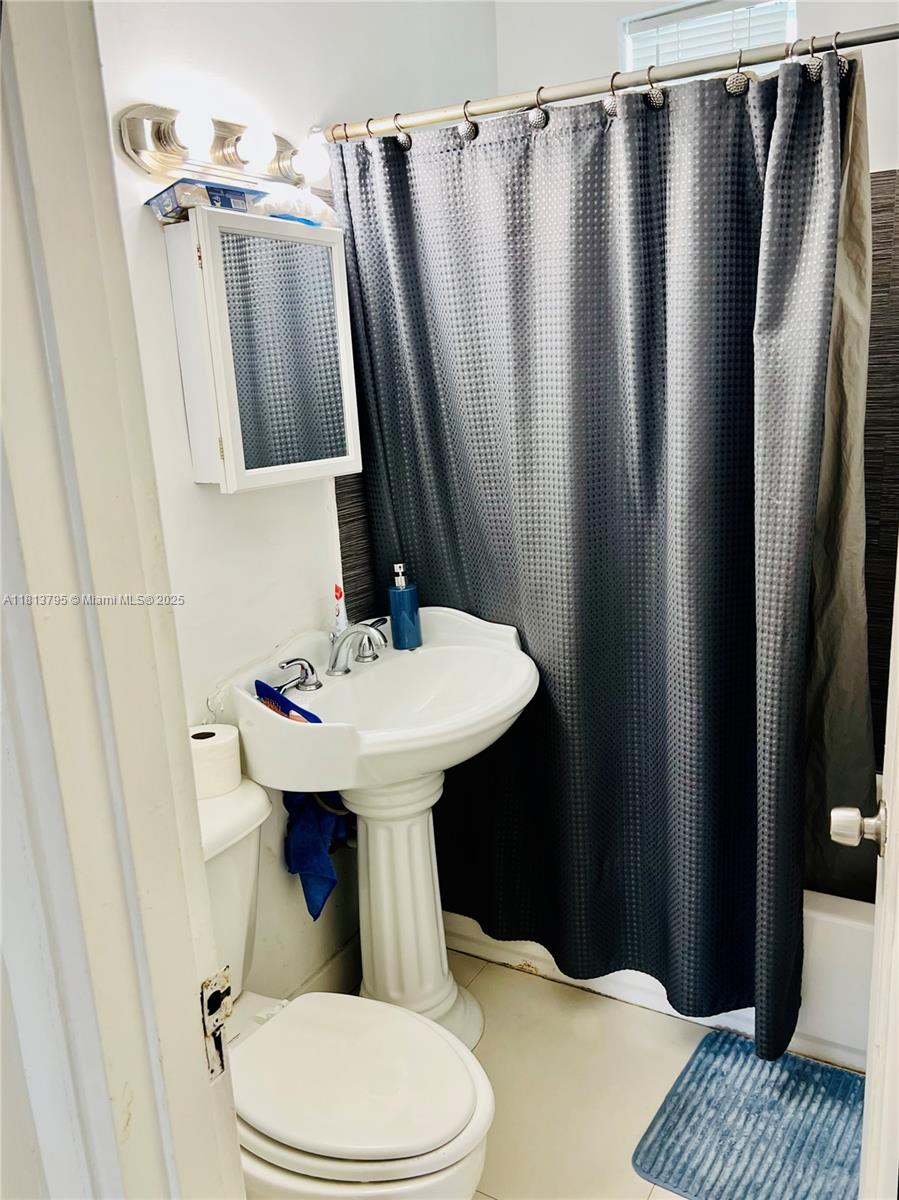 320 80th Street, Unit 6 Miami Beach, FL 33141 - Photo 23 of 33 a bathroom with a sink a toilet a mirror and vanity