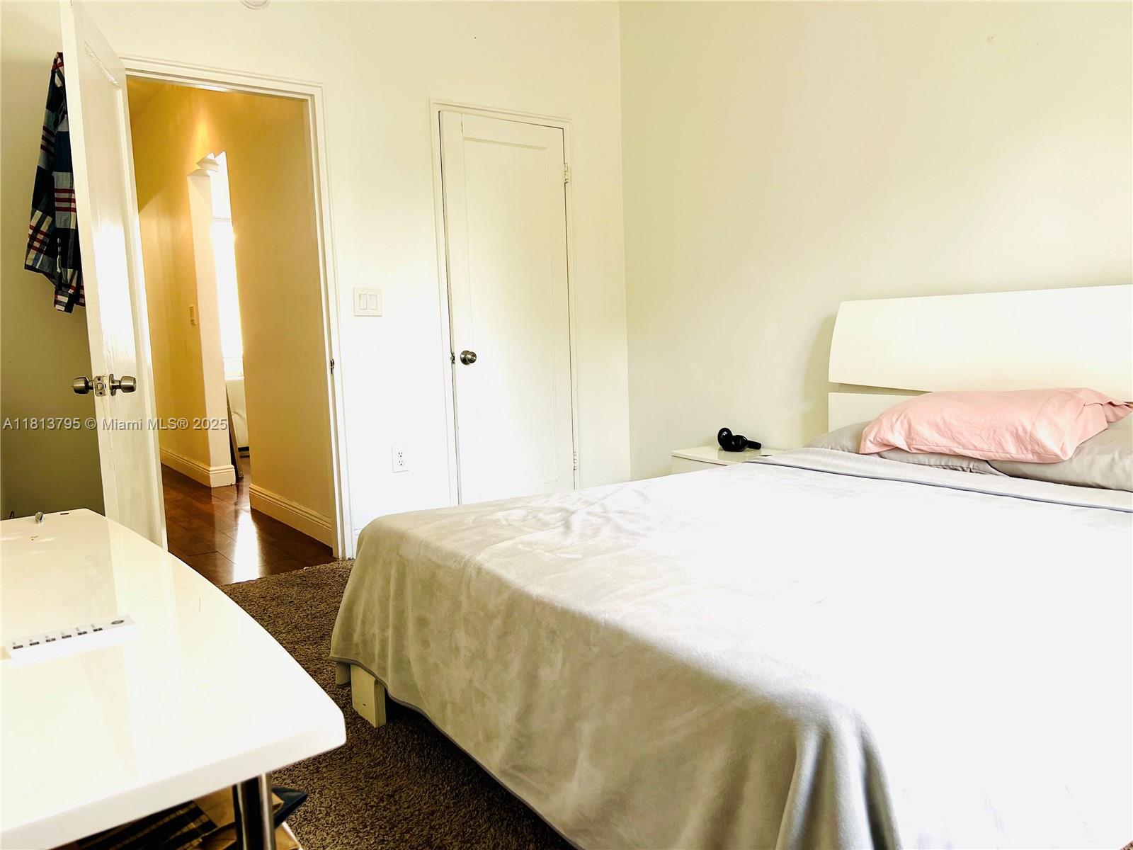 320 80th Street, Unit 6 Miami Beach, FL 33141 - Photo 26 of 33 a bedroom with a bed and a table in it