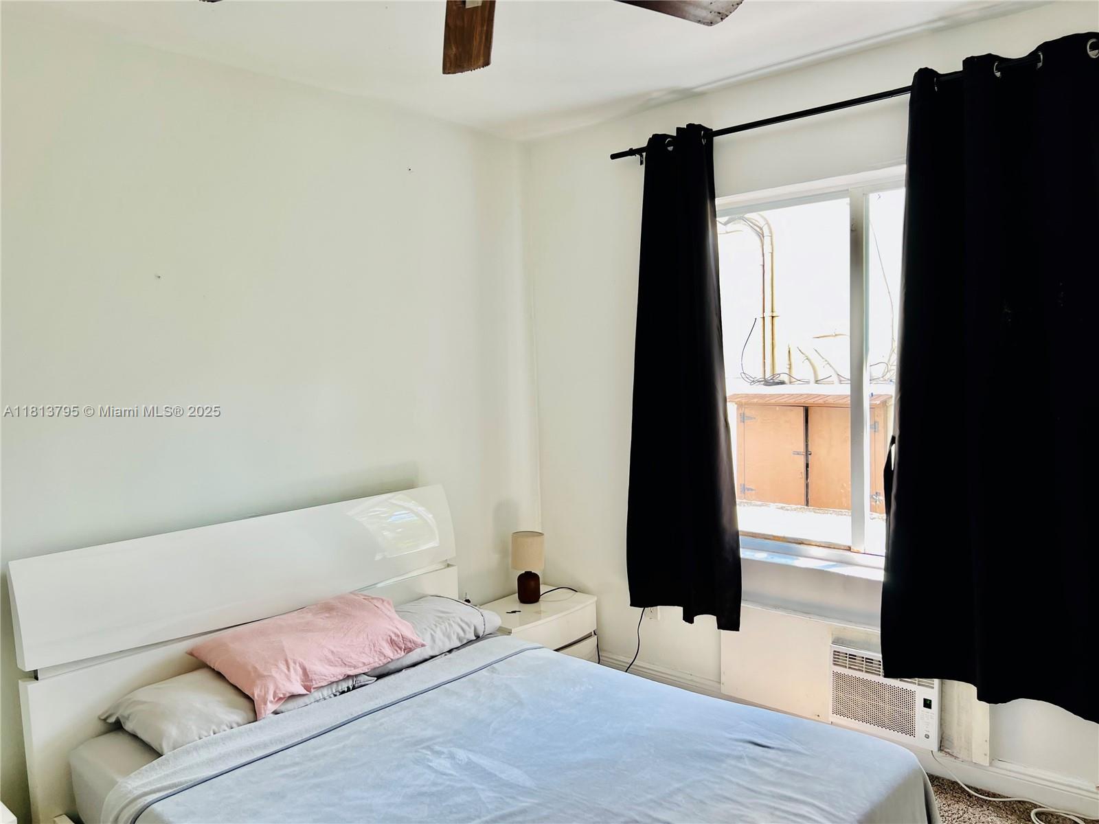 320 80th Street, Unit 6 Miami Beach, FL 33141 - Photo 27 of 33 a bedroom with a bed and a flat tv screen