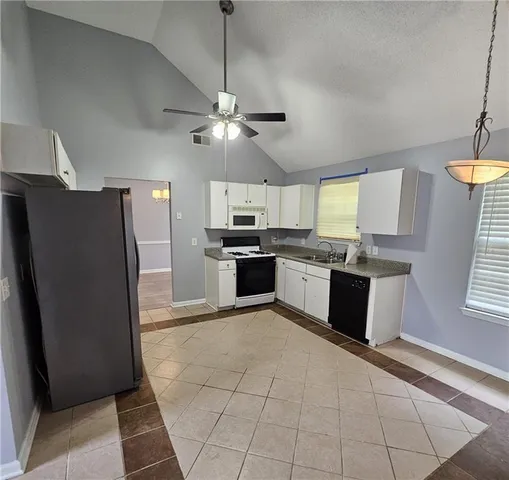 a large kitchen with stainless steel appliances granite countertop a refrigerator a sink a stove a microwave and island