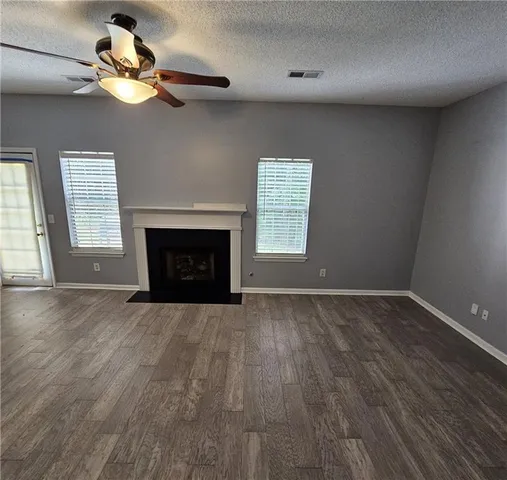 a view of an empty room with a fireplace and a window