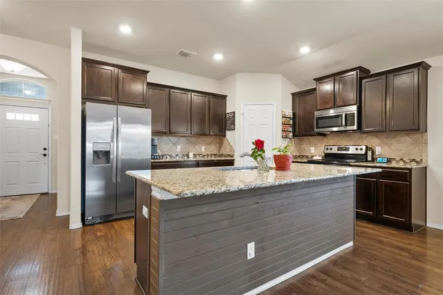 a kitchen with stainless steel appliances granite countertop a stove and a refrigerator