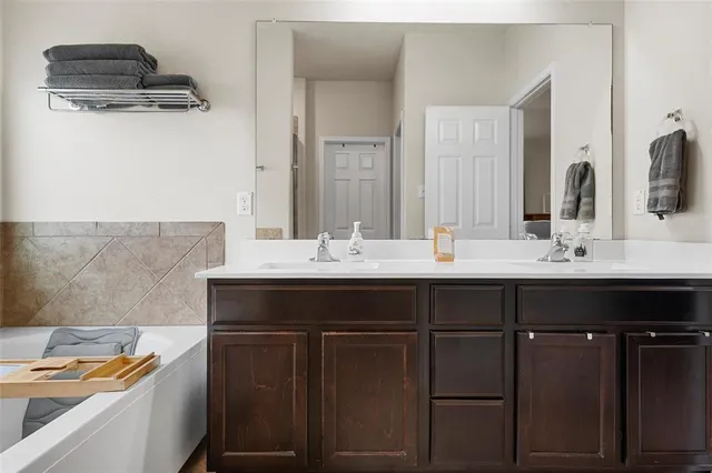 a bathroom with a sink a mirror and a bathtub