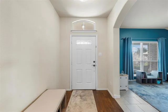 a view of a hallway with wooden floor and a living room