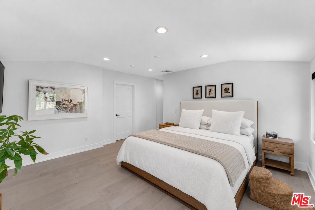 760 South San Rafael Avenue Pasadena, CA 91105 - Photo 29 of 45 a bedroom with a large bed and a potted plant