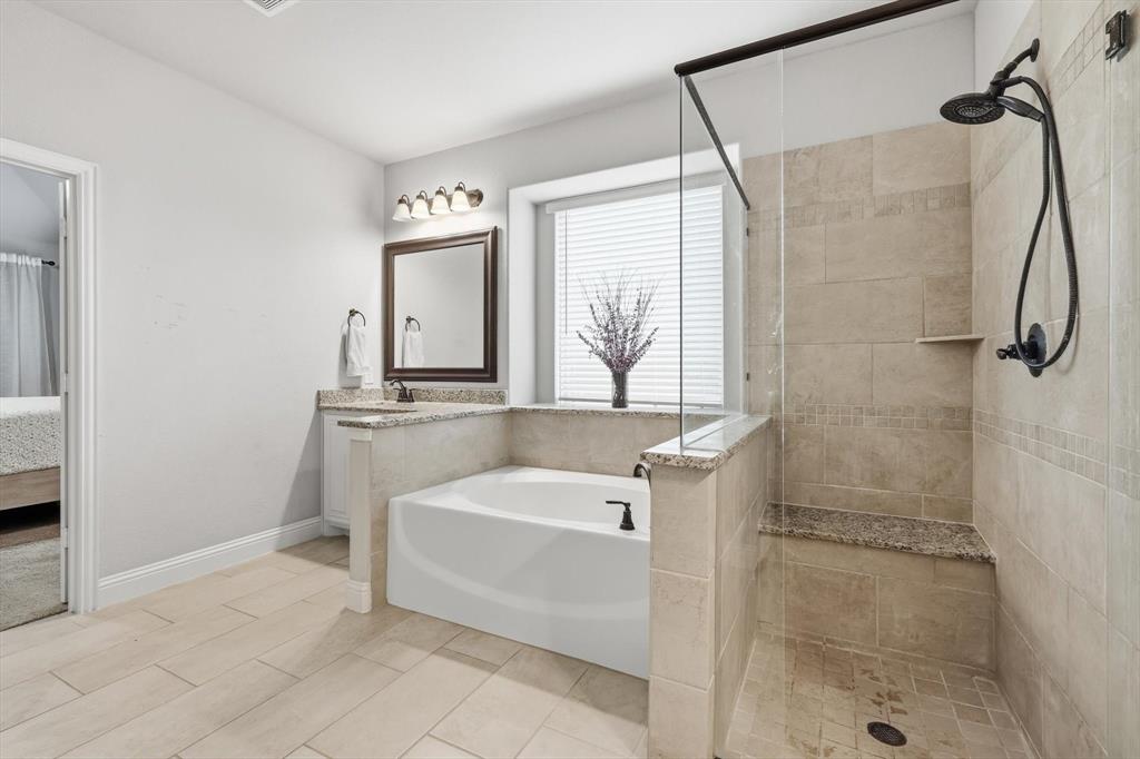924 Timber Ridge Drive Justin, TX 76247 - Photo 23 of 32 Bathroom featuring a walk-in shower with a built-in bench, a soaking tub with surrounding countertop, and tile flooring