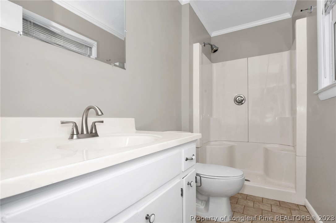 610 Arrowood Road Fayetteville, NC 28311 - Photo 20 of 26 a bathroom with a sink a toilet and shower