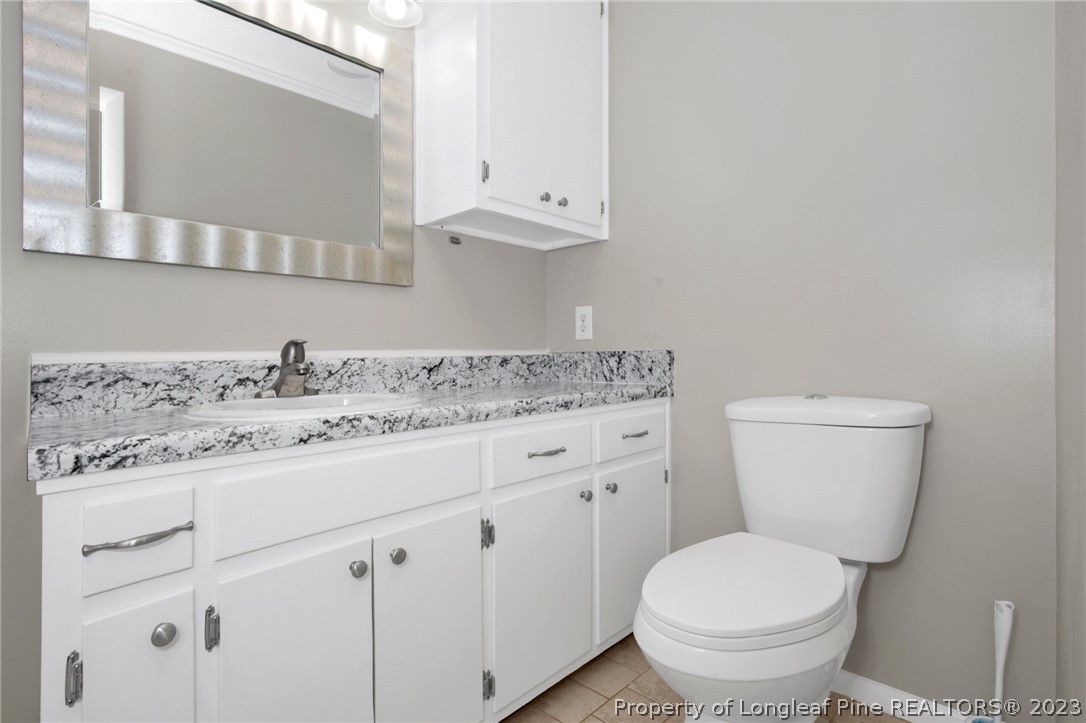 610 Arrowood Road Fayetteville, NC 28311 - Photo 22 of 26 a bathroom with a granite countertop toilet sink and mirror