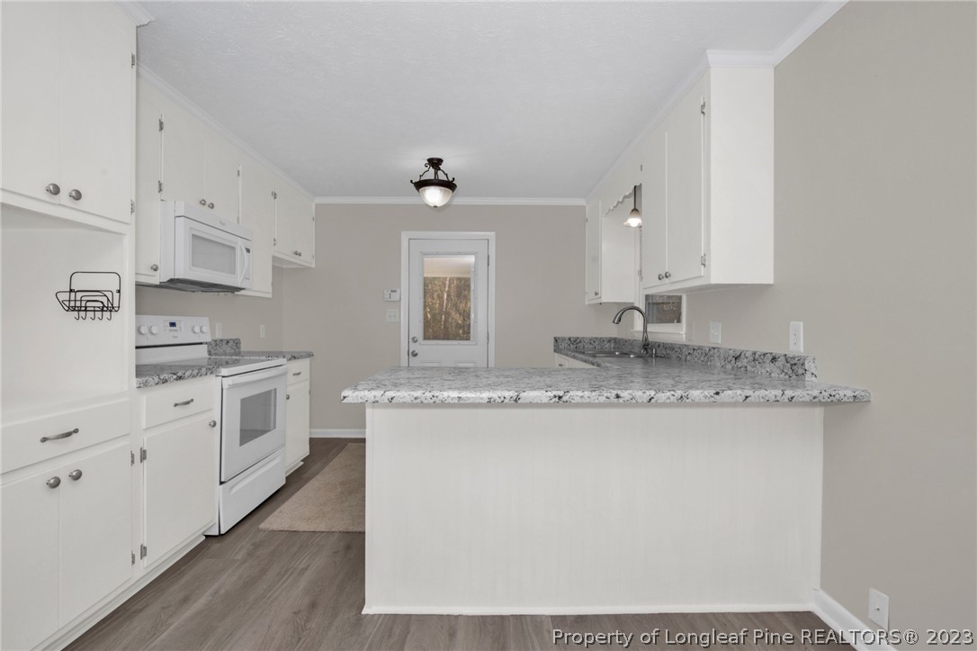 610 Arrowood Road Fayetteville, NC 28311 - Photo 23 of 26 a kitchen with granite countertop white cabinets and white appliances
